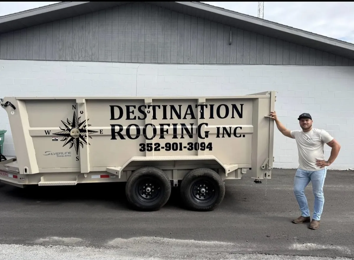 Destination Roofing owner Deston Judy beside the company dump trailer in Crystal River, Florida